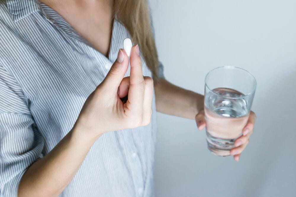Man leest doseringsschema voor Anavar met pillendoosje.