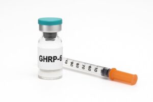 GHRP-6 peptide flesje en injectiespuit op witte achtergrond